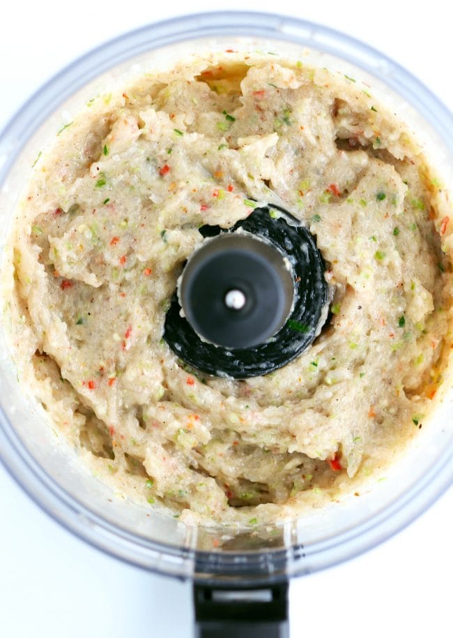 A food processor bowl with all the ingredients for Spicy Thai Shrimp Cakes blended into a thick shrimp paste.