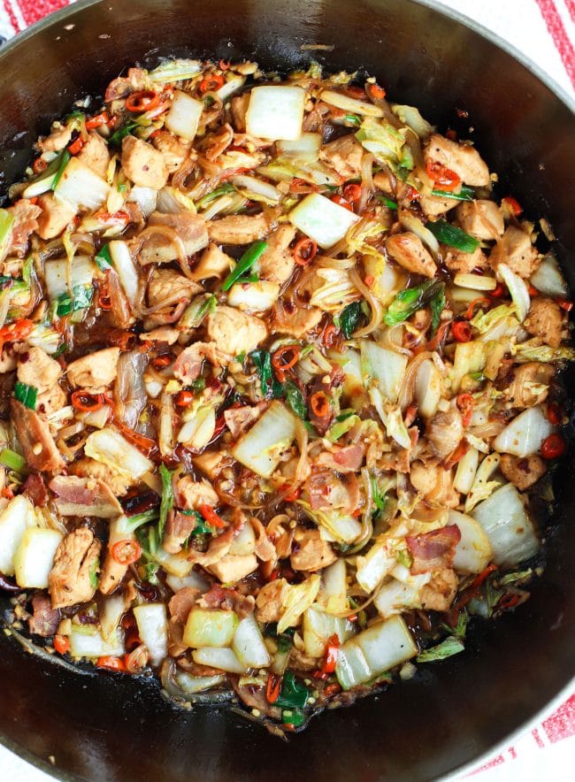 wok with stir-fried chicken, bacon, cabbage, red chilies, dried red chilies, and spring onions