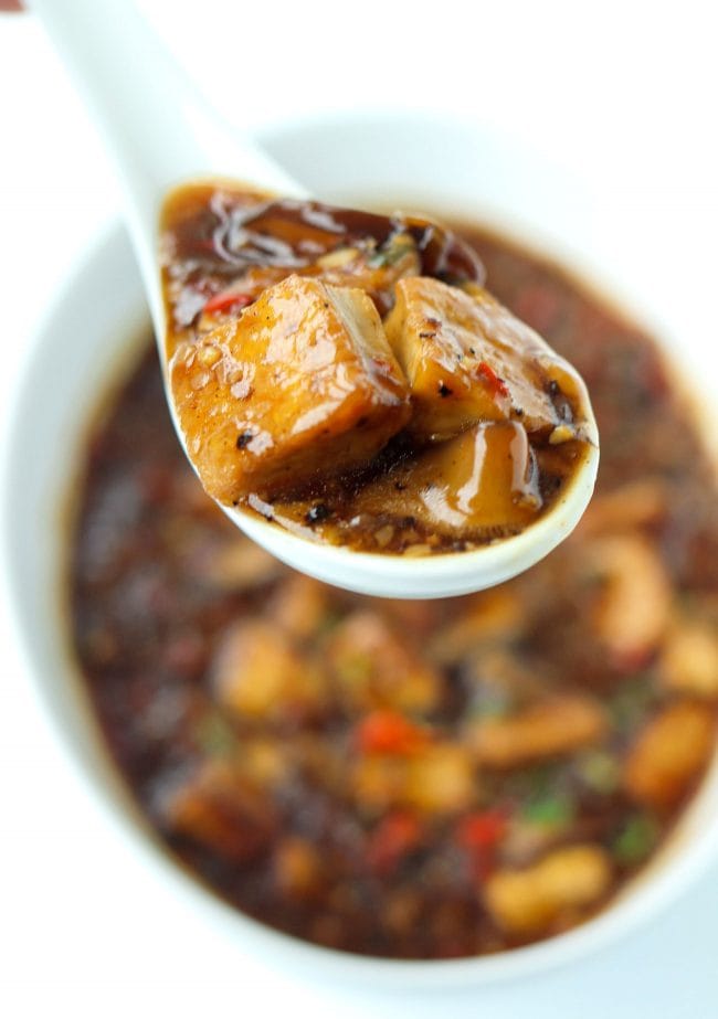 black pepper sauce tofu cubes and mushrooms on spoon
