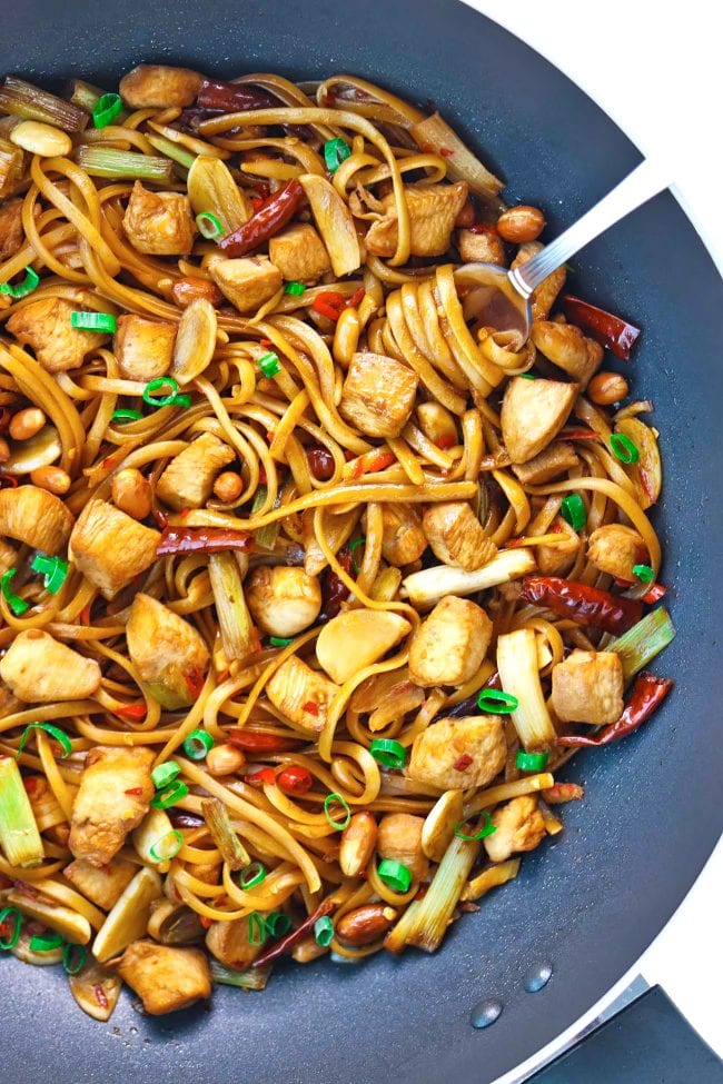 Spicy Asian Chicken Noodles twirled around a fork in a wok
