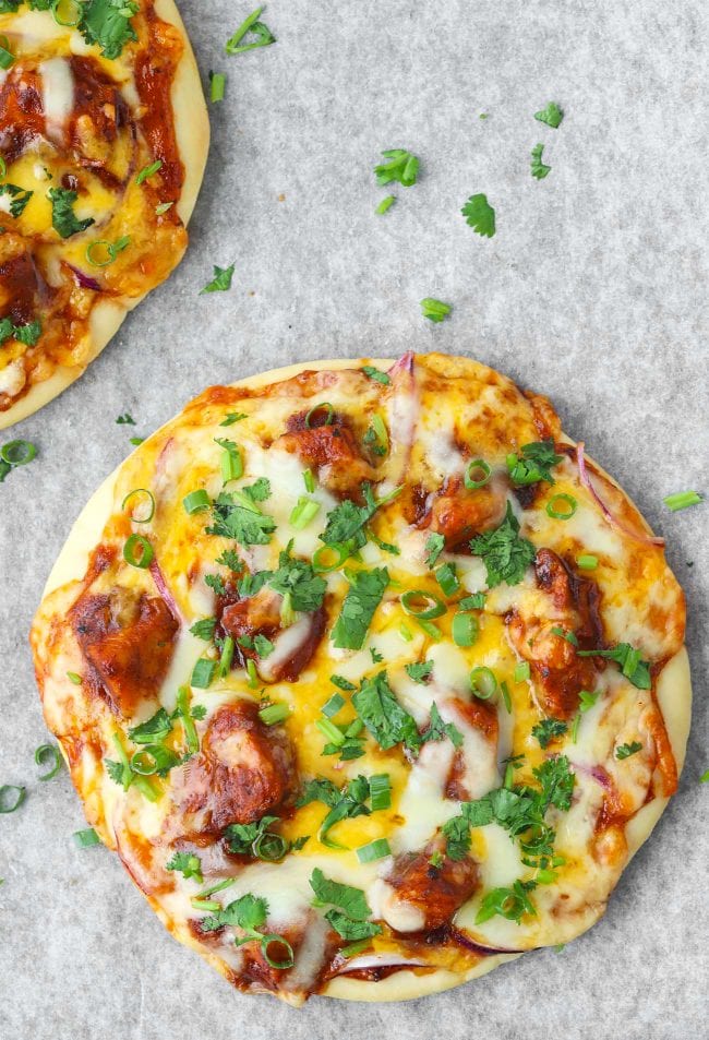 Two Spicy BBQ Chicken Pita Pizzas garnished with spring onion and chopped coriander