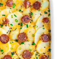 Fully baked Sausage Scalloped Potatoes in a large rectangular white baking dish.
