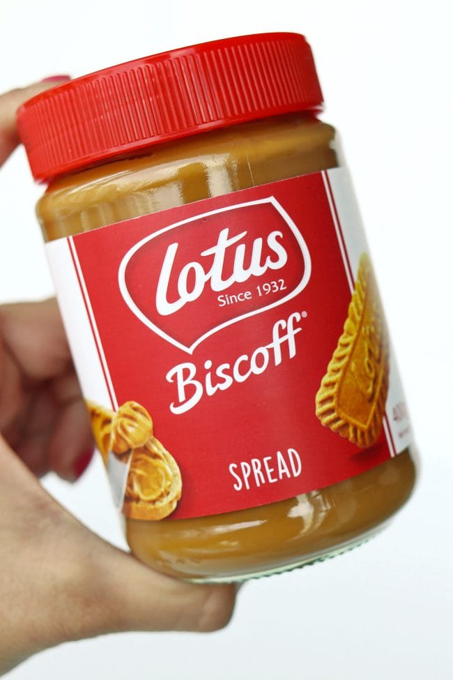 Hand holding up a jar of Lotus Biscoff Creamy Cookie Butter Spread.