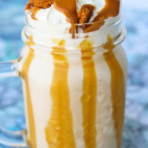 Biscoff Apple Milkshake in a mason jar glass with whipped cream, crumbled Biscoff cookies, and Biscoff spread drizzle.