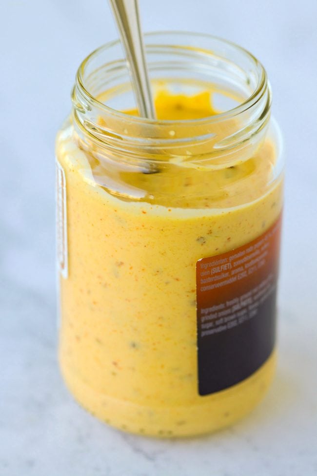 Spicy mango mayonnaise in a jar with a spoon.
