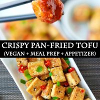 Black chopsticks holding up a fried tofu cube that's been dipped in a spicy orange sauce, and a plate with pan-fried tofu cubes sprinkled with chopped spring onion, chopped red chili, and toasted white sesame seeds.