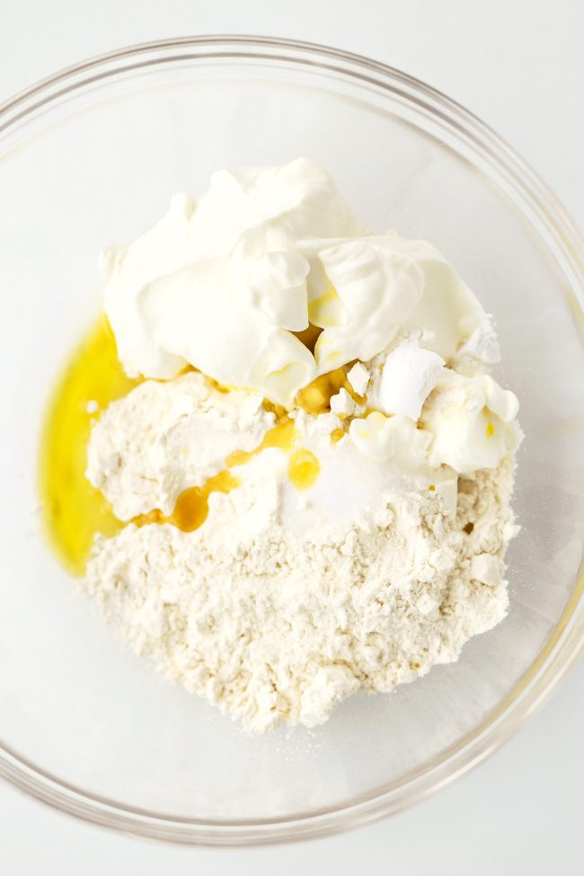 White all-purpose flour, Greek yogurt, baking powder, salt, and extra virgin olive oil in a large mixing bowl.