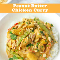 Close up front view of plate with rice topped with Peanut Butter Chicken Curry and garnished with chopped coriander and peanuts. Serving bowl with curry and bowl with chopped peanuts in the back. Text overlay "Peanut Butter Chicken Curry".