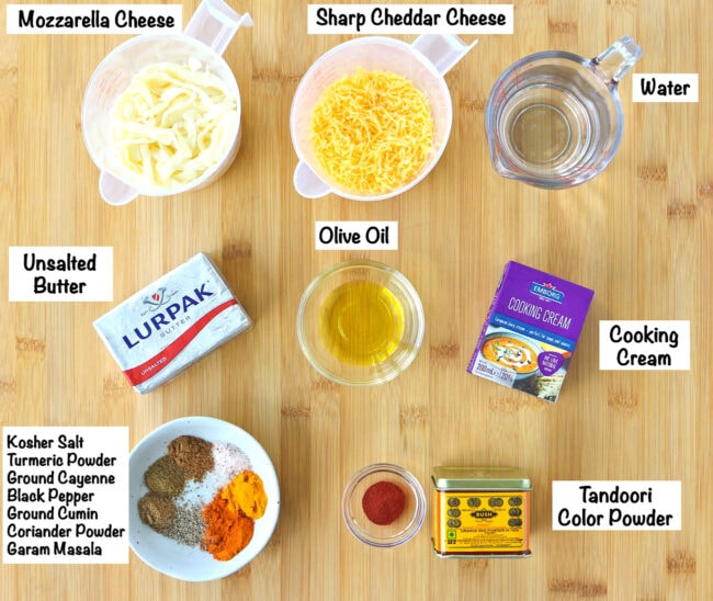 Labeled photo of more ingredients for Butter Chicken Pasta Bake on wooden board.