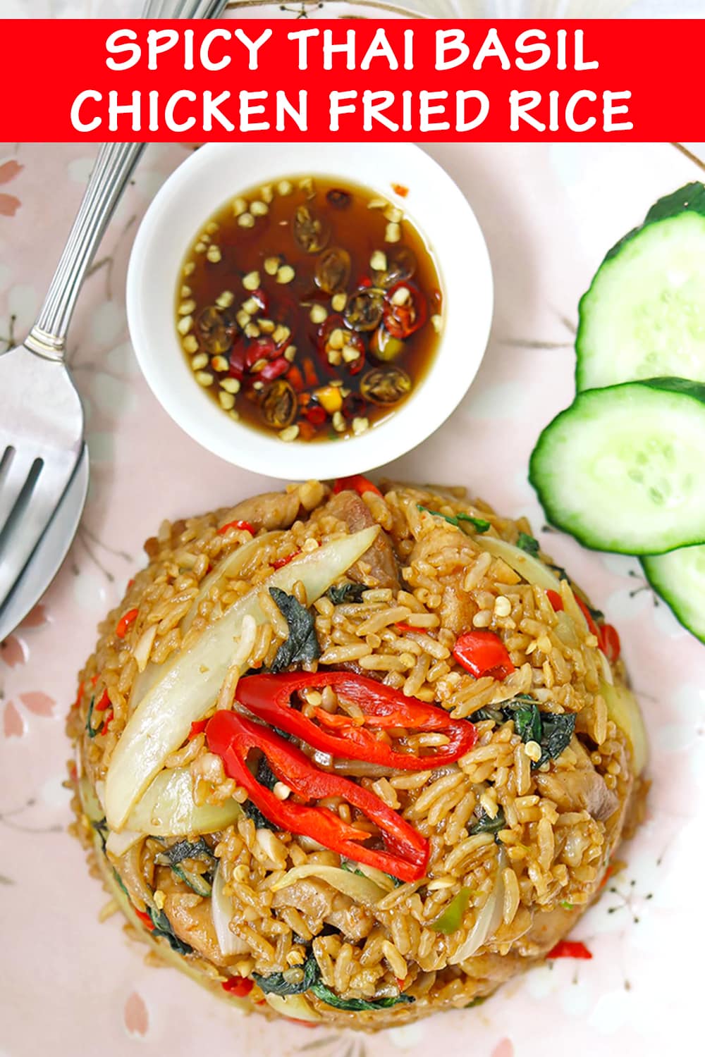 Close up top view of fried rice, cucumber slices on pink plate, fish sauce with chilies in small dish on a plate. Text overlay "Spicy Thai Basil Chicken Fried Rice".