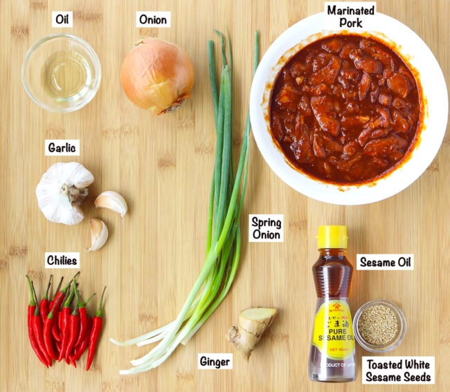 Labeled ingredients for Spicy Korean Pork Stir-fry on wooden board.