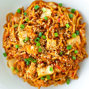 Close up top view of plate with stir-fried kimchi noodles.