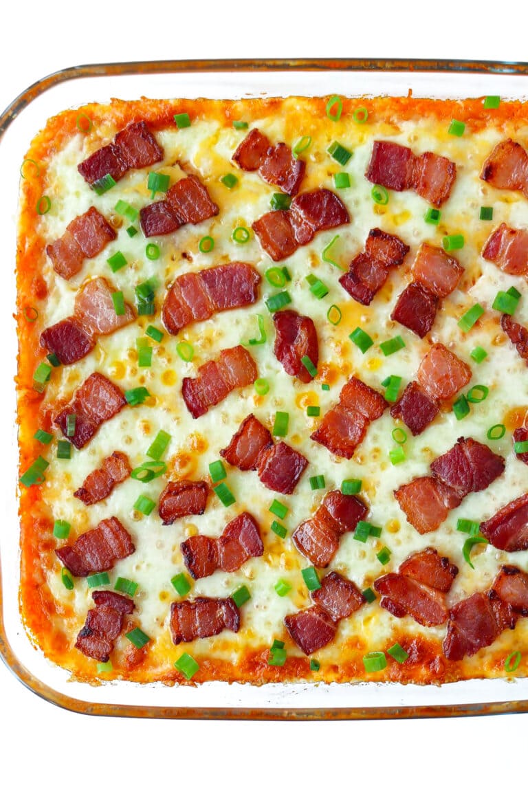 Sweet potato loaded casserole topped with melted cheese, spring onion and bacon pieces.