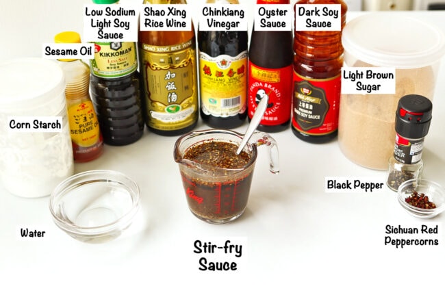 Stir-fry sauce ingredients for Spicy Pepper Chicken, and sauce in a glass measuring cup with a spoon.