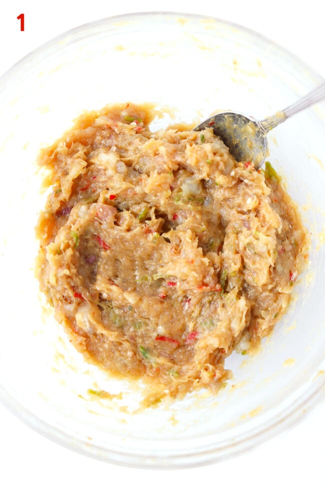 Chicken and prawn mixture in a mixing bowl with a spoon.