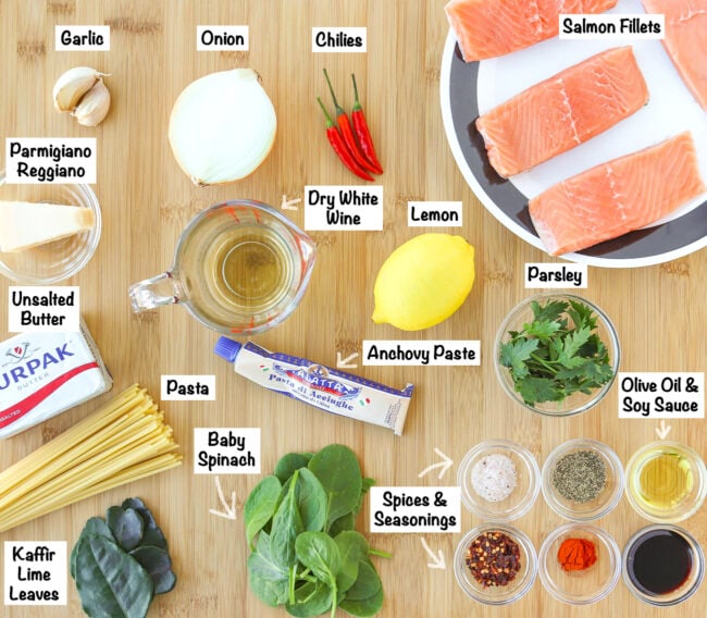 Labeled ingredients for Salmon Pasta with Anchovy-Garlic Sauce on a wooden board.