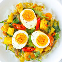 Top view of plate with rice and egg curry. Text overlay "Thai Yellow Egg Curry", "Easy Weeknight Curry!" and "thatspicychick.com".