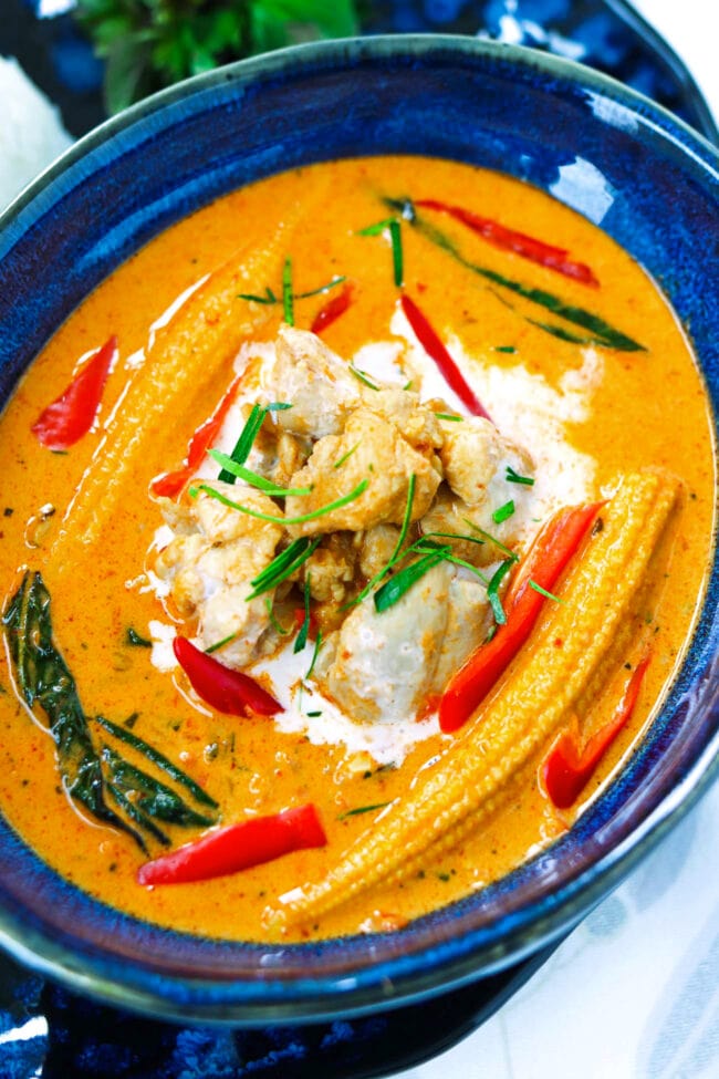 Close-up top view of panang chicken curry in small blue dish.