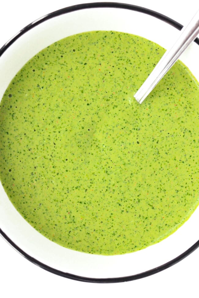 Close-up top view of bowl with Coriander and Mint Sauce and a spoon.