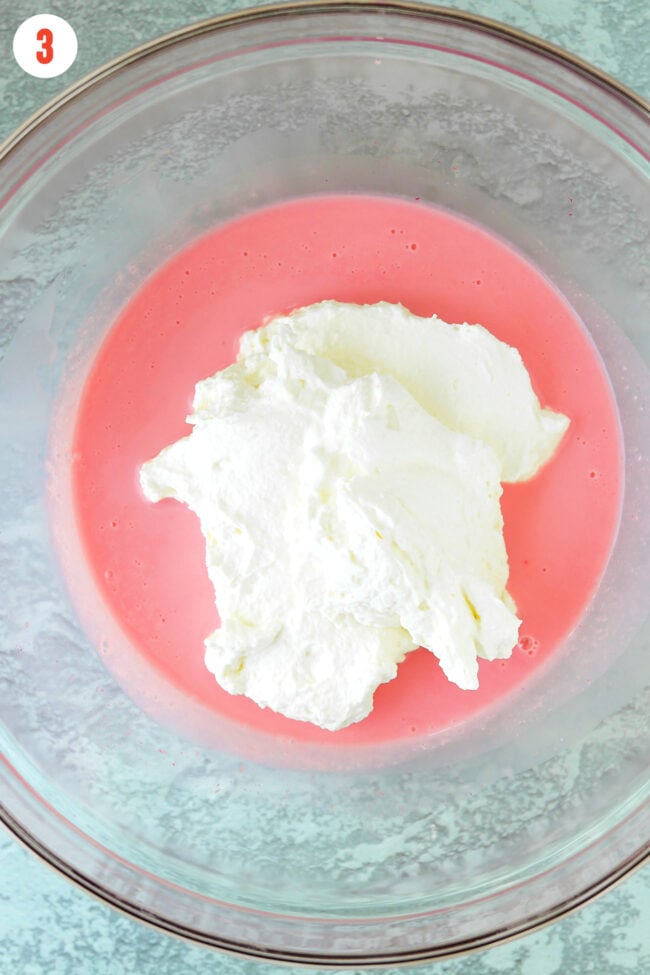 Dollop of whipped cream on top of sweetened condensed milk and flavorings mixture in mixing bowl.