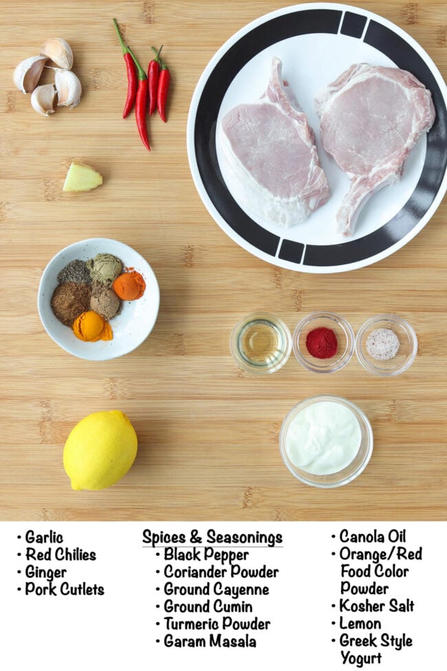Labeled ingredients for Grilled Indian Pork Cutlets on a wooden board.