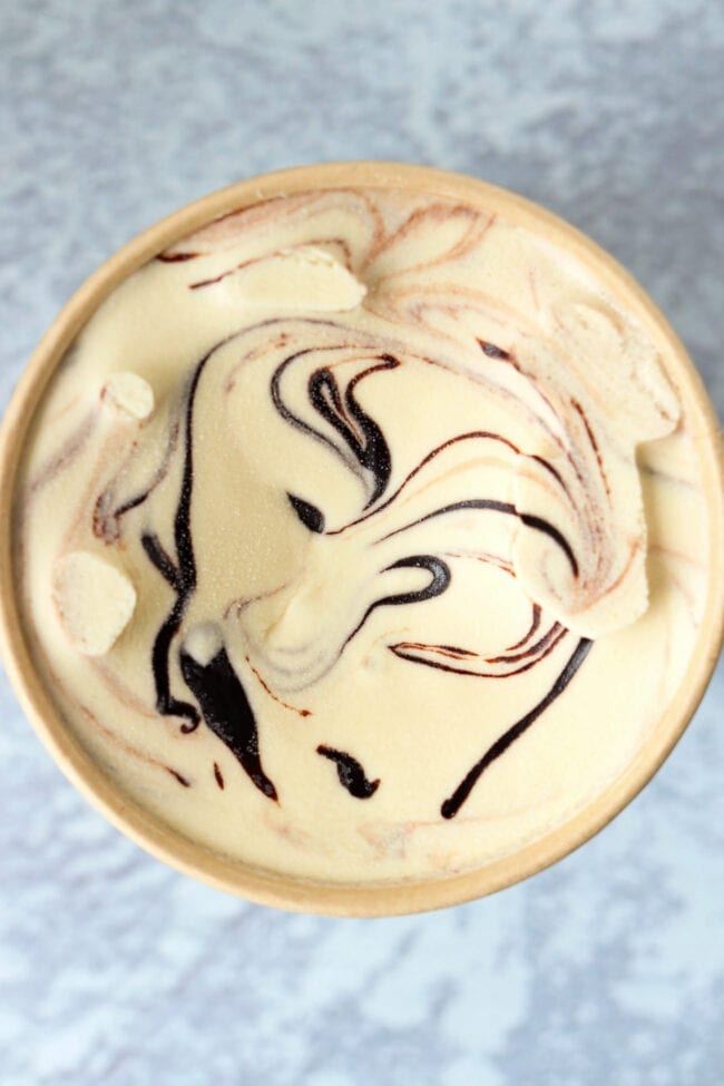 Top view of Baileys Espresso Crème Ice Cream with chocolate sauce swirl in a paper carton.