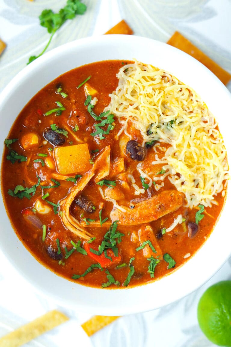 Close-up top view of soup garnished with cheese and coriander in a bowl.
