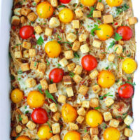 Baked pasta casserole. Text overlay "Caesar Pasta Bake with Grilled Cajun Shrimp" and "thatspicychick.com".