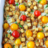 Front view of baked casserole with croutons. Text overlay "Caesar Pasta Bake with Juicy Grilled Shrimp" and "thatspicychick.com".