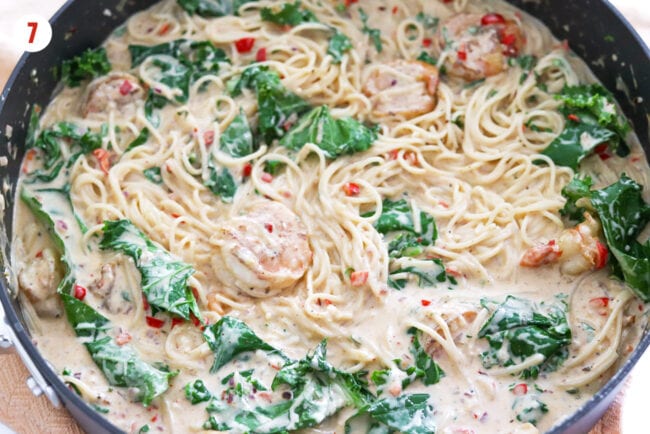 Caesar pasta with shrimp and baby kale in pan.