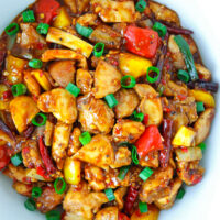 Top view of serving bowl with a spicy chicken stir-fry dish. Text overlay "Chicken with Spicy Black Bean Sauce" and "thatspicychick.com".