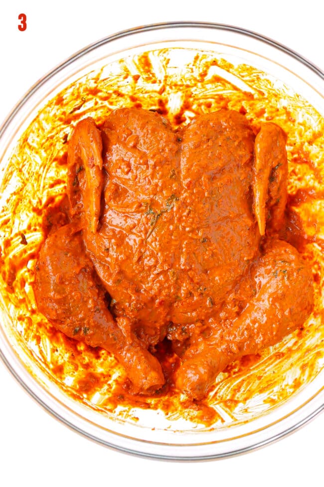 Marinated Tandoori chicken in a mixing bowl.