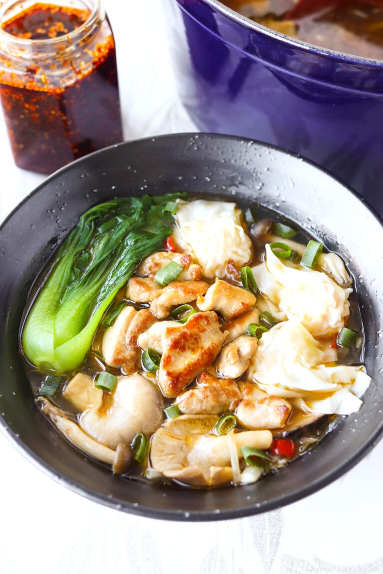 Spicy Udon Noodle Soup with Chicken & Mushrooms in black bowl.