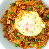 Top view of fried rice on a plate. Text overlay "Kimchi Fried Rice with Pork Belly" and "thatspicychick.com".