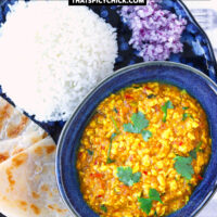 Plate with paneer dish in bowl, paratha, and rice. Text overlay "Paneer Bhurji Gravy", "Scrambled Cottage Cheese with Onion & Tomato Gravy", and "thatspicychick.com".