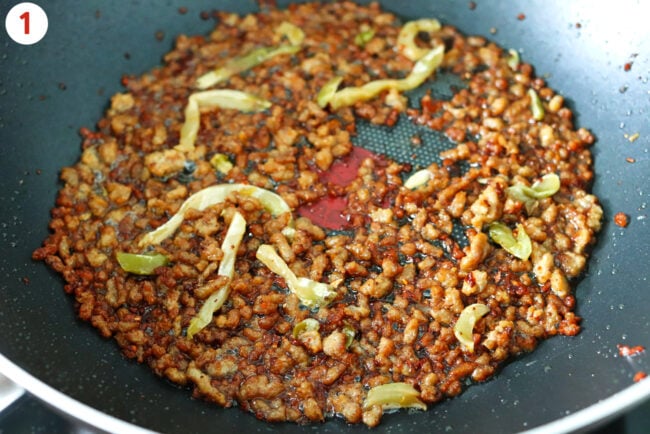 Crispy browned ground pork with mustard tuber in a wok.
