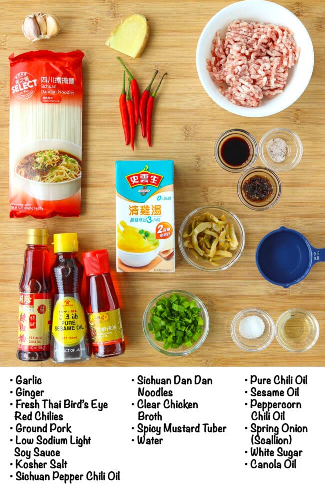 Labeled ingredients for Spicy Dan Dan Noodles on a wooden board.