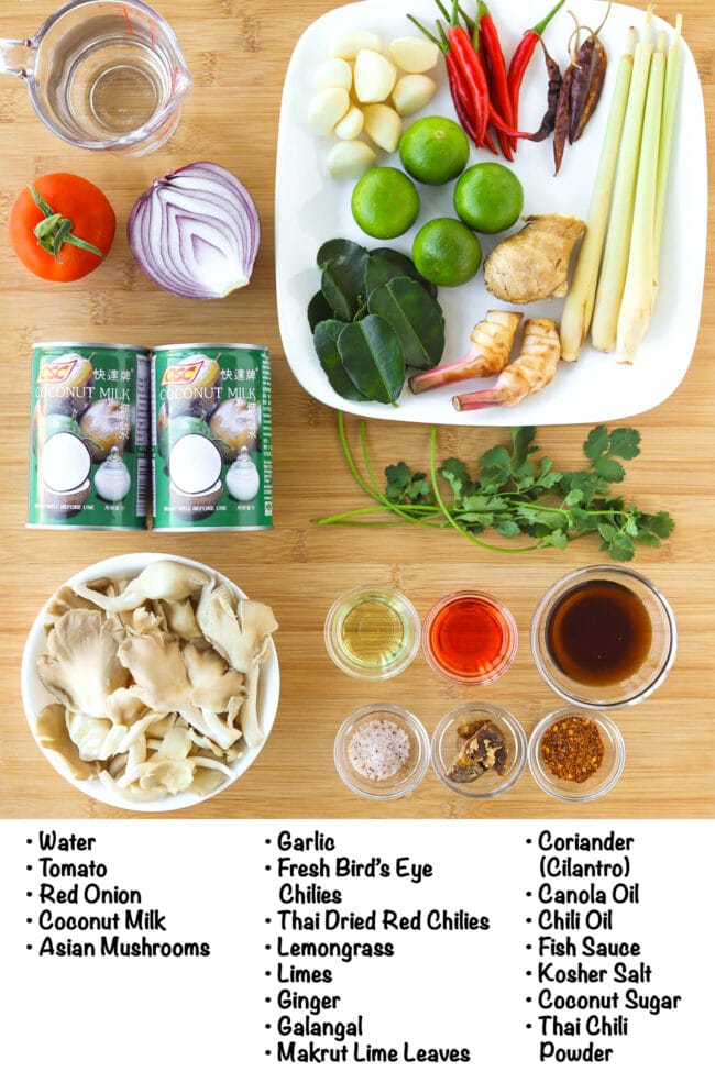 Labeled ingredients for Tom Kha Gai on a wooden board.