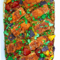 Fish and rice baked in dish. Text overlay "Thai Chili Jam Salmon & Rice Bake" and "thatspicychick.com".