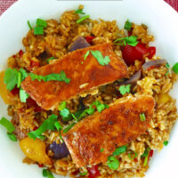 Top view of fish and rice on plate. Text overlay "Thai Chili Jam Salmon & Rice Bake" and "thatspicychick.com".