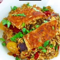 Front view of fish and rice on plate. Text overlay "Thai Chili Jam Salmon & Rice Bake" and "thatspicychick.com".