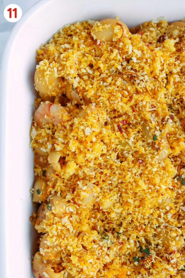 Top view of mac and cheese with unbaked breadcrumbs topping in dish.