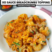 Front view of plate and baking dish with mac and cheese. Text overlay "XO Sauce Mac and Cheese with Buttery Shrimp & XO Sauce Breadcrumbs Topping" and "thatspicychick.com".