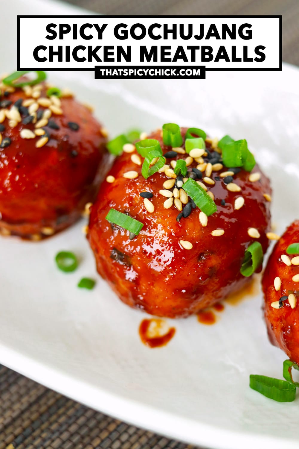 Closeup of spicy Korean meatball on a serving plate. Text overlay "Spicy Gochujang Chicken Meatballs" and "thatspicychick.com".