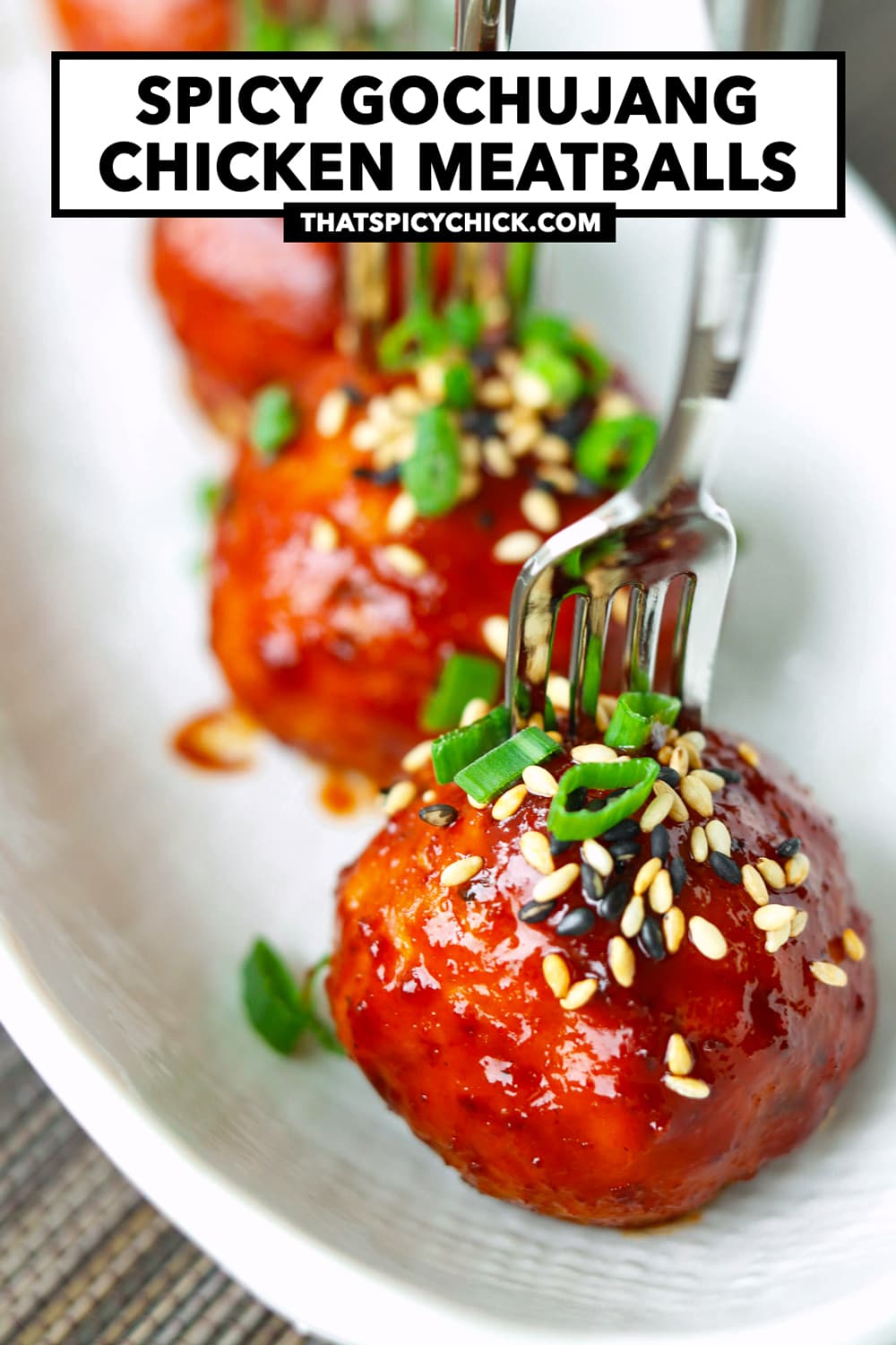 Plate with spring onion and sesame seeds garnished spicy meatballs pierced with mini forks. Text overlay "Spicy Gochujang Chicken Meatballs" and "thatspicychick.com".