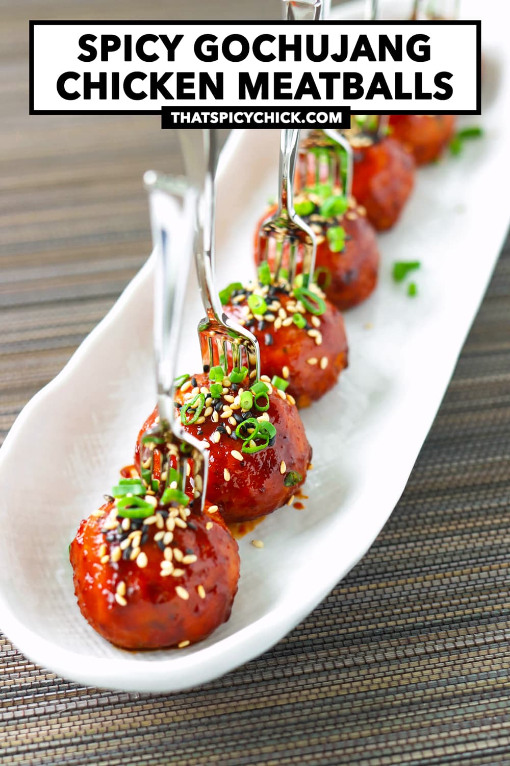 Meatballs with pierced with mini forks on serving plate. Text overlay "Spicy Gochujang Chicken Meatballs" and "thatspicychick.com".