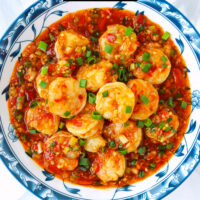Top view of plate with spicy shrimp dish. Text overlay "Dry Braised Shrimp", "Sichuan Gan Shao Xia" and "thatspicychick.com".