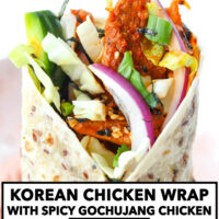 Hand holding up a spicy chicken wrap. Text overlay "Korean Chicken Wrap with Spicy Gochujang Chicken" and "thatspicychick.com".