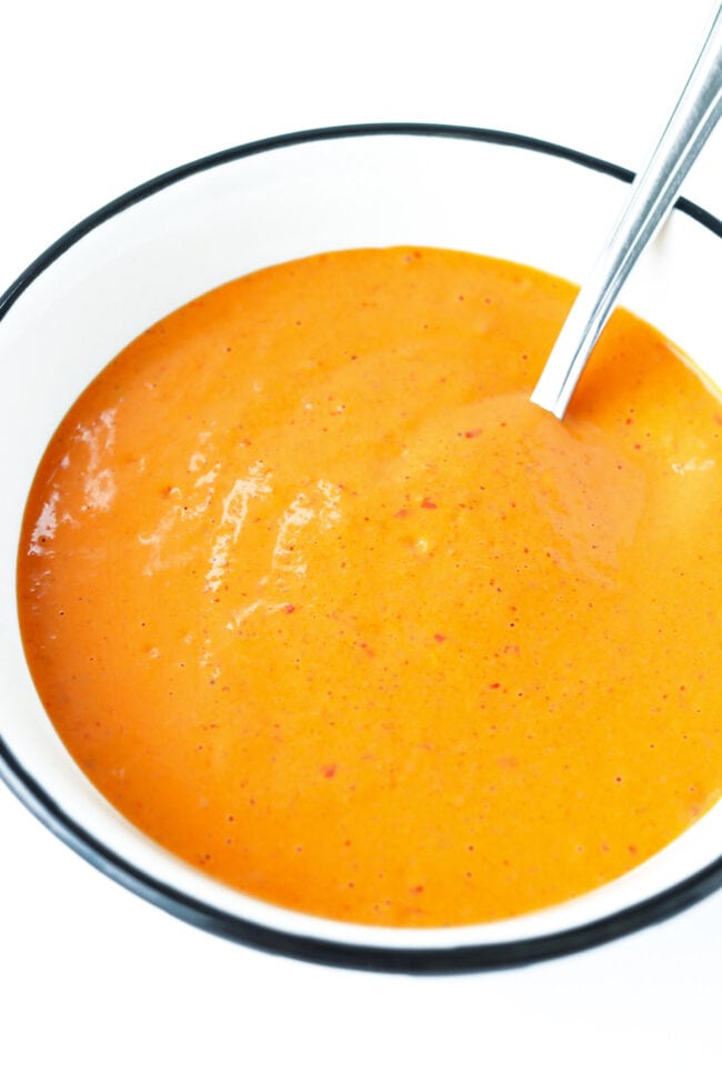 Closeup of harissa mayonnaise in a bowl with a spoon.