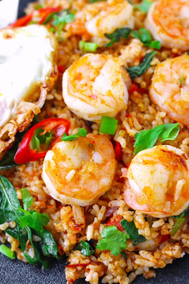 Closeup of fried rice with jumbo shrimp on a plate.